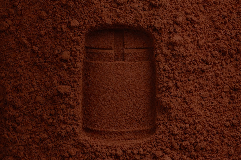Artistic cocoa powder forming Syren Spreads best beauty chocolate jar shape in textured brown pile.